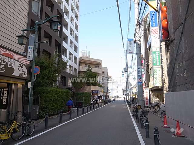 敷地北東側の前面道路。店舗や事務所が建ち並ぶ駅前の通りです。