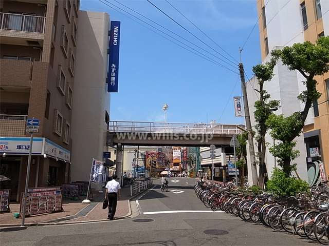 敷地東側の前面道路。周辺は店舗や事務所が多く立ち並ぶ駅前の商業地です。