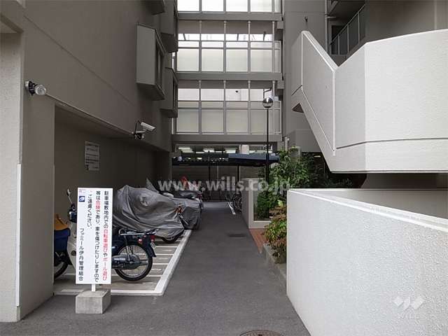 バイク置き場と駐輪場。奥上部は、棟を結ぶ渡り廊下。