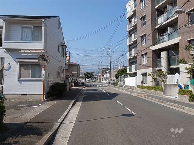 敷地南側の前面道路。周辺は一戸建てとマンションが混在する住宅地です。
