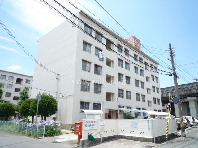 東園田団地5号棟の外観（東側から）　敷地の西側には名神高速道路が走っています。