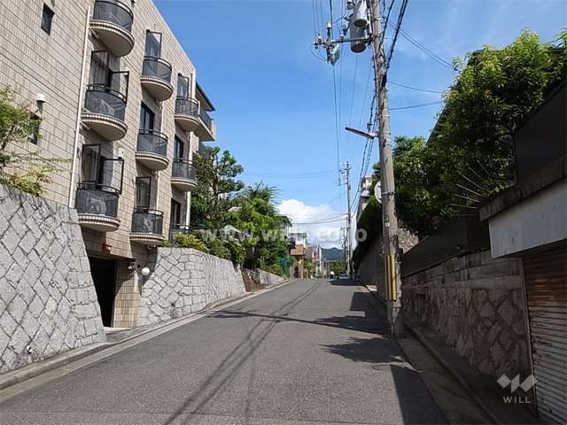 敷地東側の前面道路。周辺は閑静な住宅地。敷地は南ひな壇状になっています。