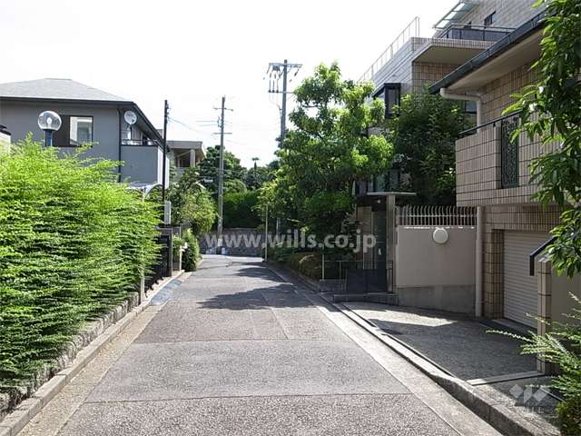 敷地北側の前面道路。各家の生け垣や植栽の緑がきれいです。