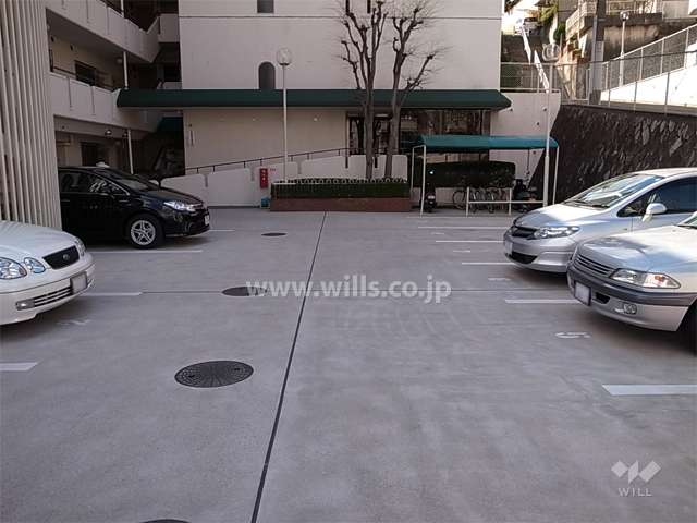 敷地内駐車場（平面式）と駐輪場。正面、奥がエントランスです。