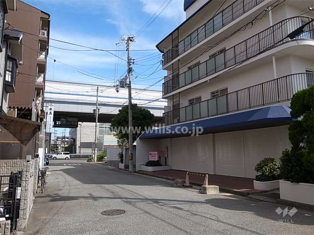 敷地西側の前面道路。建物1階には店舗部分があります。