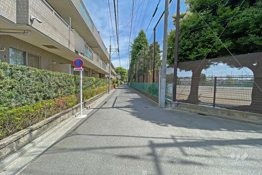 敷地の南東側前面道路（南西側から）。向かいは『開進第一中学校』のグラウンドで開放感があります。