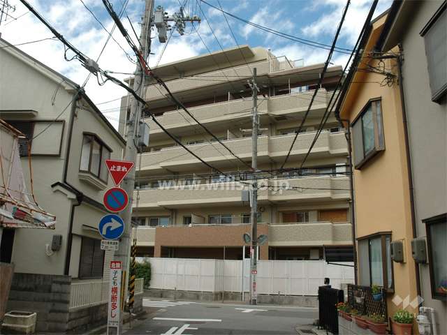 周辺は一戸建てとマンションが混在する住宅地。（南東側からの外観）