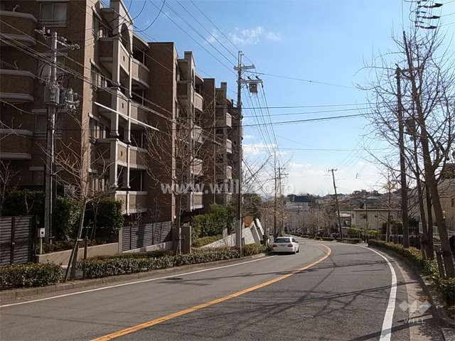 高台の住宅地に立地。敷地の南西側は2車線のバス通りに面しています。