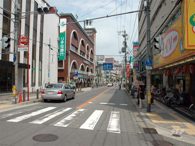 敷地北側の通り、各種店舗が建ち並んでいます。