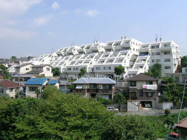 箕面リリーヴィレッジの全景。周辺は一戸建てが中心に建ち並ぶ静かな住宅地です。