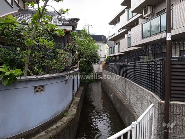 敷地の南側には水路が流れています。周辺は一戸建てが中心に建ち並ぶ住宅地。
