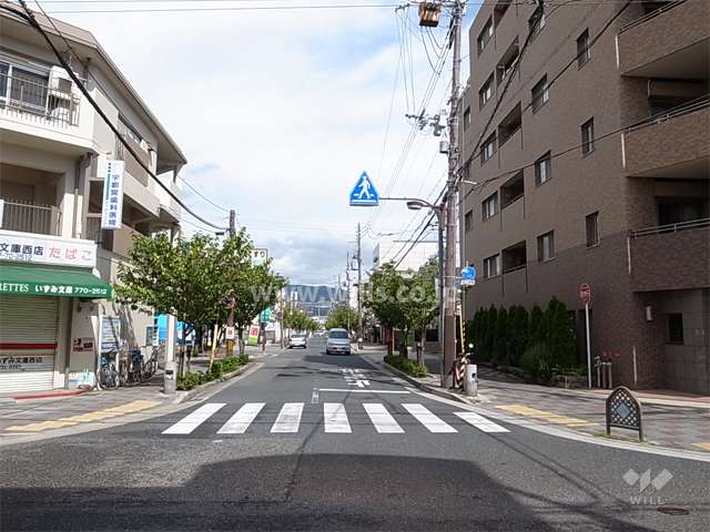 敷地西側の前面道路。通り沿いには店舗も並んでいます。