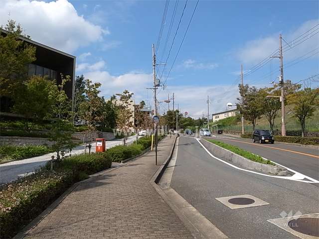 敷地の北東側の前面道路。街路樹のきれいなバス通りで、すぐ目の前にバス停があります。