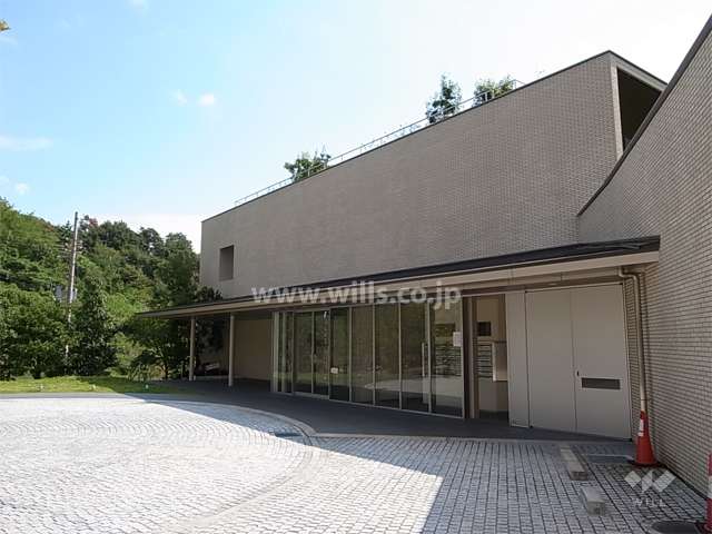 アプローチに向かって庇が伸びるエントランス