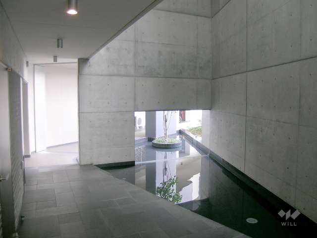 コンクリート打ち放しと水盤がお洒落なエントランスホール