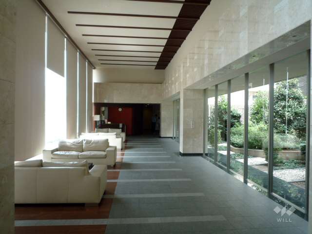 中庭に面したエントランスホールはガラス張りで開放的な空間。ソファセットが設置されています。