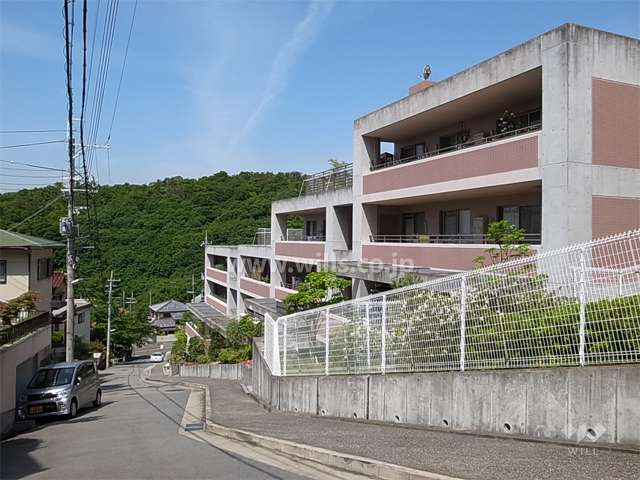 西、南の斜面地にひな壇型に建てられています。周辺は緑豊かで閑静な住宅地です。