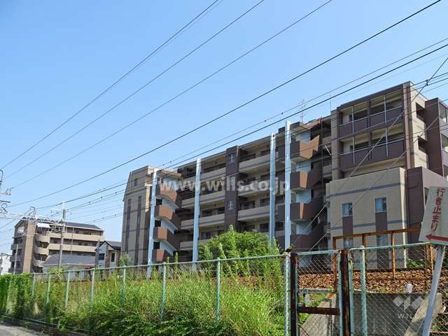 ワコーレ神戸森北町の遠景（北西側から）。マンションの北側には道路を挟んで阪急神戸線が通っています。
