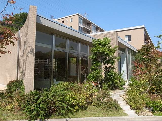 植栽に囲まれたガラス張りのエントランス棟