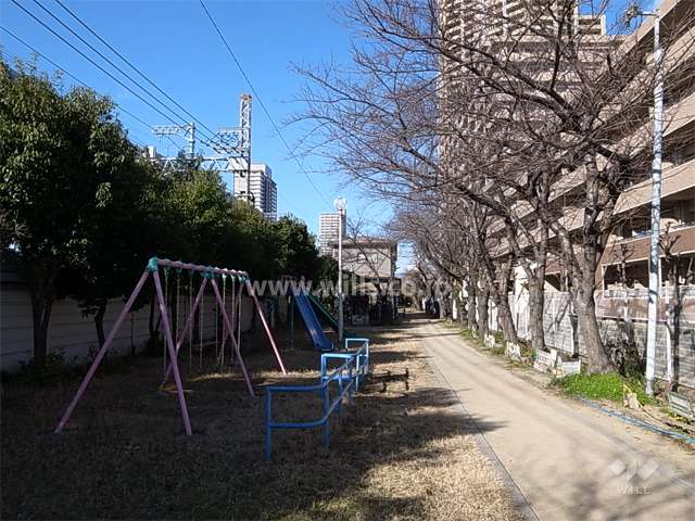 スプリングコートコンフォートタウン（C棟）南側の公園。公園と緑道を挟んで、阪神電車が走っています。