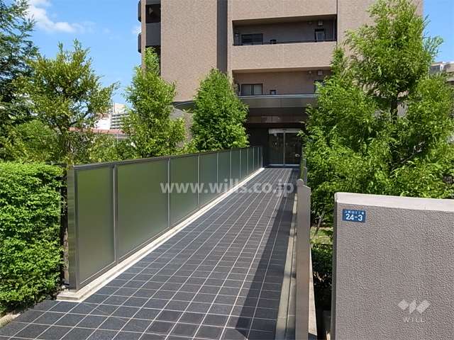 エントランスアプローチ（敷地内の庭園の上を渡る橋になっています。）