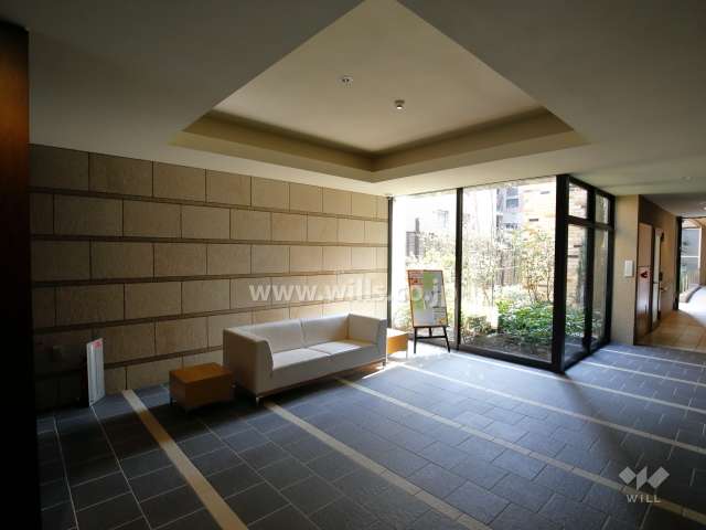 中庭に面したエントランスホール。タイルと石、ブビンガの木目が温もりのある雰囲気を出しています。