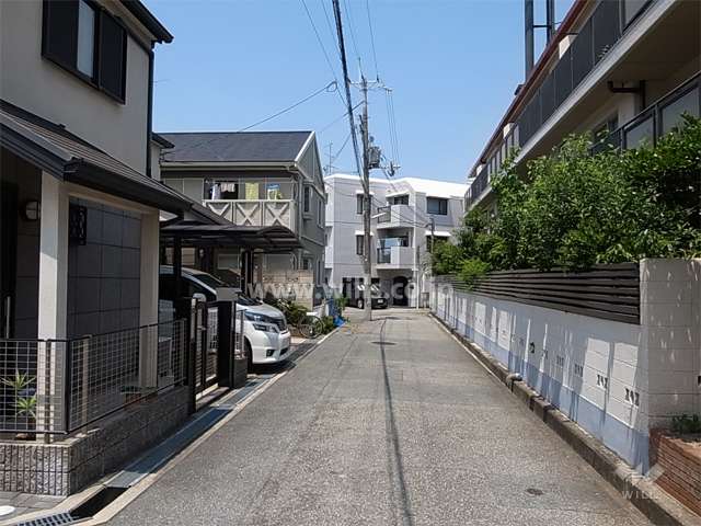 南側の前面道路。南と東の2方が接道。周辺は一戸建てが立ち並ぶ静かな住宅地です。