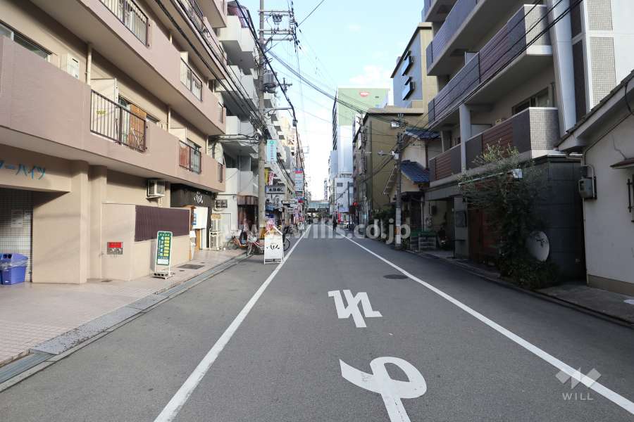 南側前面道路（西側から）店舗が立ち並んでいます。